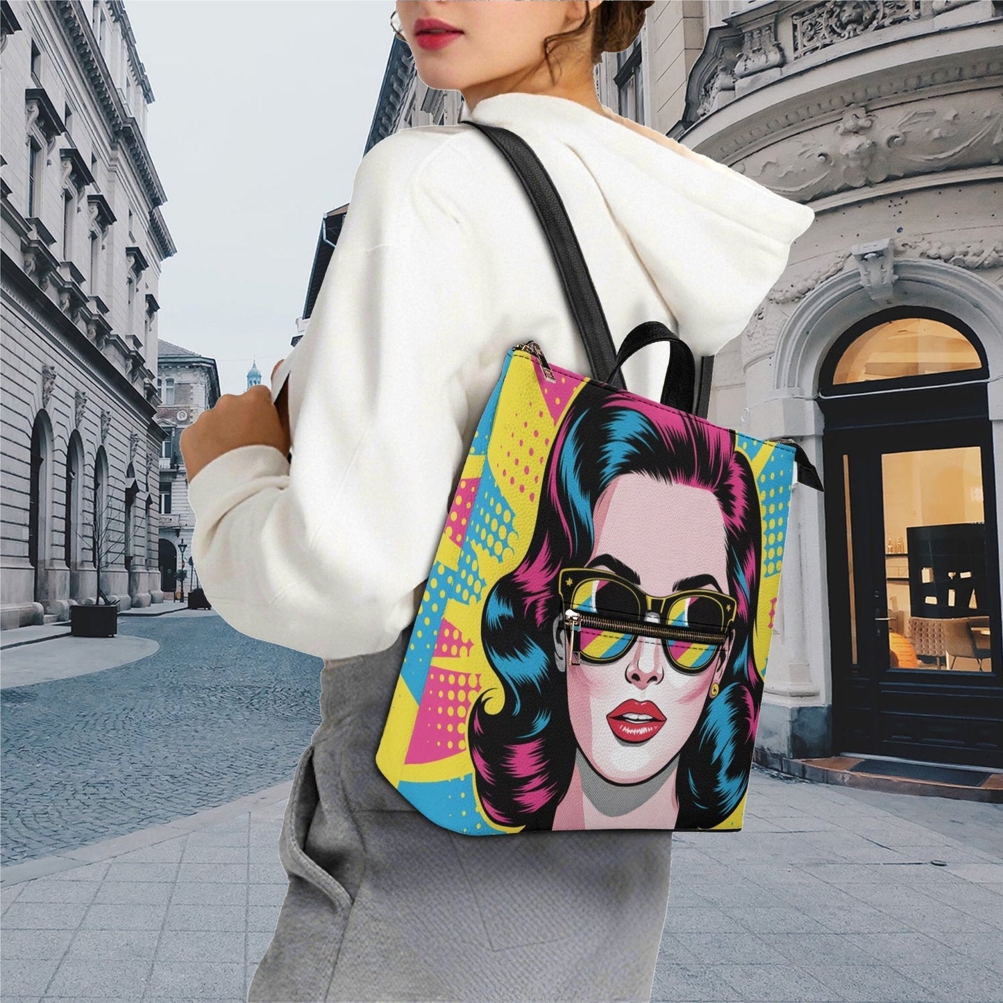 Person wearing a colorful backpack with a graphic design of a face on a city street.